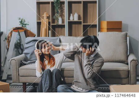 Asian Female discussing new project with male colleague. Young woman talking with young Asian man with financial on sofa in home office 117464648