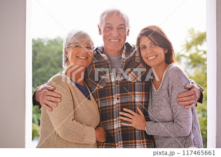 Portrait, senior and parents with daughter, outdoor and home for summer for happiness, smile and joy. Family, women and man embrace on patio for visit of girl to house of old mother and father 117465661