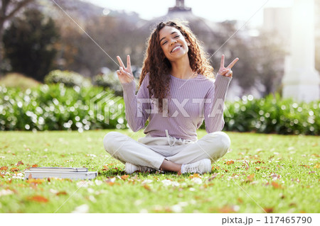 Woman, college student and peace sign on grass for portrait with books, smile or studying at campus. Girl, person and happy with icon, symbol or emoji on lawn for education, learning and development 117465790