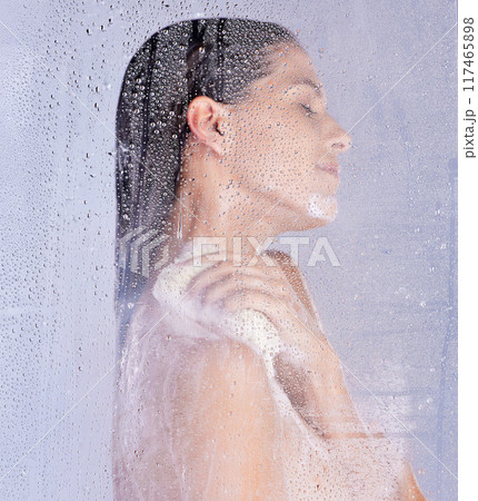Shower, washing and hand of woman with puff in studio for hygiene, treatment or morning routine on white background. Body care, glass and model with eyes closed for grooming, water drops or wellness 117465898