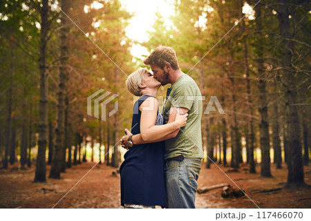 Couple, forest and happy with kiss for love with support, care and trust in Germany. People, relationship and affection in woods on holiday or vacation and travel for bonding, embrace and memories 117466070
