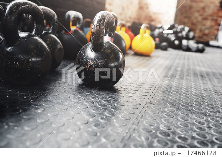 Equipment, kettlebells and fitness in gym floor for exercise, workout and bodybuilding or health. Weights, wellness and strength training for sports, muscle and power in interior with no people Equipment, kettlebells and fitness in gym floor for exercise, workout and bodybuilding or health. Weights, wellness and strength training for sports, muscle and power in interior with no people 117466128