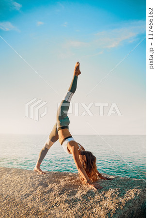 Woman, stretching and pilates wellness or beach exercise, yoga and standing splits position for body health. Fitness, balance workout and seaside for peace outside in nature, vitality and zen 117466162