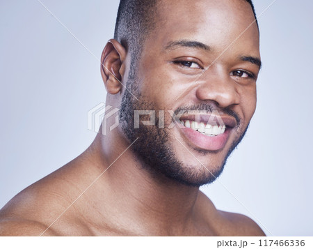 Black man, happy and skincare in studio portrait, facial treatment and cosmetics on blue background. Male person, healthy and pamper for dermatology, grooming and confident for smooth or clean skin 117466336