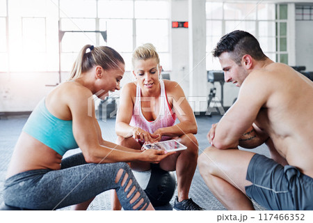 Happy people, fitness and friends with tablet for browsing workout, schedule or routine at gym. Group or team with smile in rest on technology for online tutorial, exercise or research at health club 117466352