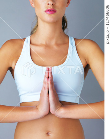 Prayer hands, body and girl with meditation in studio for wellness, peace or energy on grey background. Zen, balance or model with calm, breathing or holistic exercise for self care or mental health 117466606