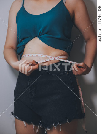 fat woman, fat belly, chubby, obese woman hand holding excessive belly fat with measure tape, woman diet lifestyle concept fat woman, fat belly, chubby, obese woman hand holding excessive belly fat with measure tape, woman diet lifestyle concept 117466846