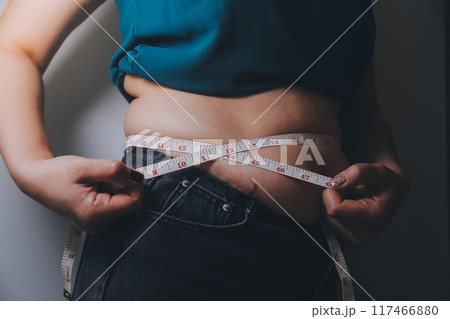 fat woman, fat belly, chubby, obese woman hand holding excessive belly fat with measure tape, woman diet lifestyle concept fat woman, fat belly, chubby, obese woman hand holding excessive belly fat with measure tape, woman diet lifestyle concept 117466880