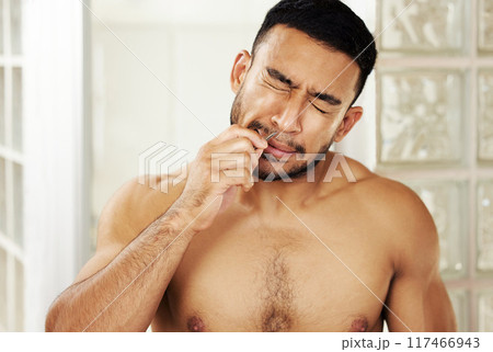 I think I should invest in a nose trimmer. Cropped shot of a young man using tweezers to pluck his nose hair. I think I should invest in a nose trimmer. Cropped shot of a young man using tweezers to pluck his nose hair. 117466943