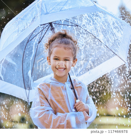 Young girl, portrait and umbrella outdoor in rain with raincoat, water and smile for fun in winter. Child, face and cold weather in park with jacket, cover and happy attitude for storm on weekend 117466978