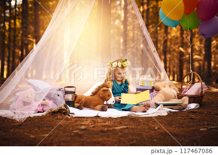 Nature, girl child and reading book on picnic for development, education or fairytale story. Forest, fantasy and young kid on blanket with costume for relax, weekend break or literature in Canada Nature, girl child and reading book on picnic for development, education or fairytale story. Forest, fantasy and young kid on blanket with costume for relax, weekend break or literature in Canada 117467086