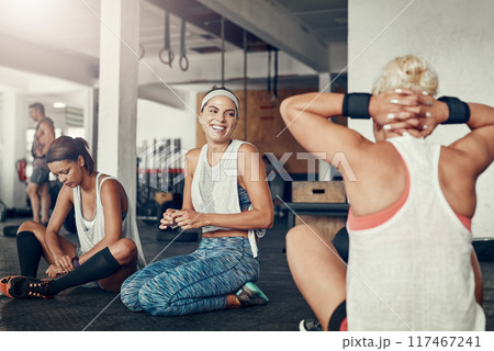 Happy woman, fitness and break with friends for workout, exercise or indoor training together on floor at gym. Young, active group and talking in recovery, rest or relax for warm up at health club Happy woman, fitness and break with friends for workout, exercise or indoor training together on floor at gym. Young, active group and talking in recovery, rest or relax for warm up at health club 117467241