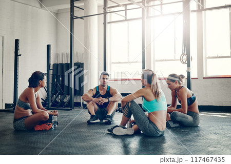 People, fitness and discussion with team for meeting, workout routine or social on gym floor. Active group in conversation, rest or break after indoor training or exercise together at health club 117467435