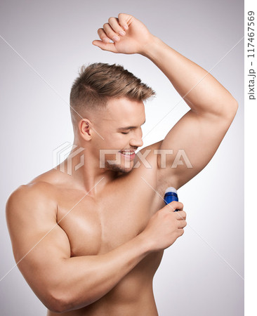Man, deodorant and armpit in studio for health, cleaning and wellness or self care routine. Male person, skincare and happy for hygiene in bathroom for cosmetics and perfume by white background 117467569