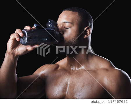 Shirtless, black man and studio for drinking water after exercise, fitness training with refreshment. Healthy, male bodybuilder and bottle with aqua for workout, dark background with thirsty athlete 117467682