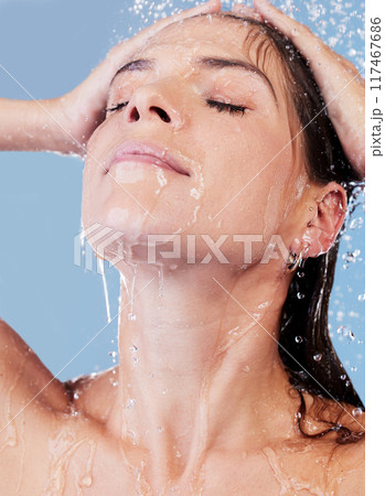 Shower, water and woman washing hair for shampoo, cosmetics and wellness cleaning or conditioner. Female person, haircare and rinsing scalp in studio blue background for skin care or morning routine 117467686