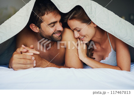 Happy couple, relax and bed with sheets for love, bonding or awake from morning together at home. Man and woman lying with smile under duvet, fabric or linen in bedroom for care, support or affection Happy couple, relax and bed with sheets for love, bonding or awake from morning together at home. Man and woman lying with smile under duvet, fabric or linen in bedroom for care, support or affection 117467813