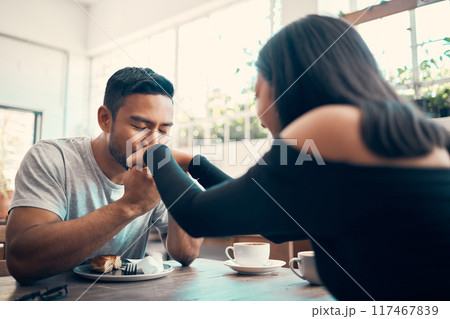 Romantic, in love and affectionate dating couple together on a date at a cafe or restaurant. Lovely, caring and loving young boyfriend kissing and holding his girlfriend or lovers hands Romantic, in love and affectionate dating couple together on a date at a cafe or restaurant. Lovely, caring and loving young boyfriend kissing and holding his girlfriend or lovers hands 117467839