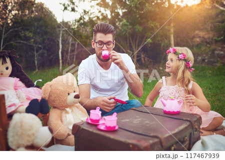 Father, tea party and girl child in garden for nature picnic with toys, teddy bear and suitcase for table. Daughter, dad and memory together for playing or entertainment, bonding and love in outdoor 117467939