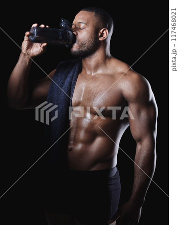 Black man, drink and water or protein shake in studio for hydration, exercise and fitness or workout. Bodybuilder, wellness and liquid by dark background for African athlete, towel and heath Black man, drink and water or protein shake in studio for hydration, exercise and fitness or workout. Bodybuilder, wellness and liquid by dark background for African athlete, towel and heath 117468021