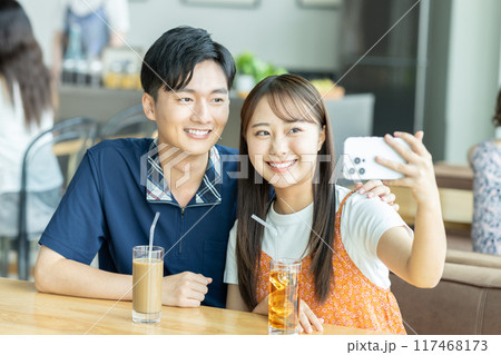 カフェで写真を撮る若いカップル カフェで写真を撮る若いカップル 117468173