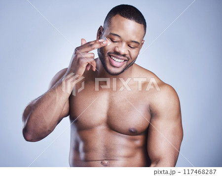 Black man, apply spf and cream in studio for skincare, ointment and cosmetics on blue background. Person, lotion and pamper for dermatology, grooming and moisturizer for hydration or skin treatment Black man, apply spf and cream in studio for skincare, ointment and cosmetics on blue background. Person, lotion and pamper for dermatology, grooming and moisturizer for hydration or skin treatment 117468287