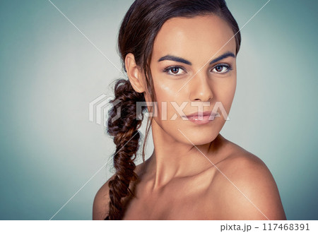 Portrait, glow or girl with skincare results on blue background for beauty, wellness or natural shine. Makeup, proud model or confident woman in studio for dermatology, smooth face or facial health 117468391