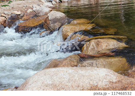 Fast mountain river running among large stones Fast mountain river running among large stones 117468532