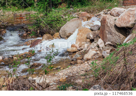 Fast mountain river running among large stones 117468536