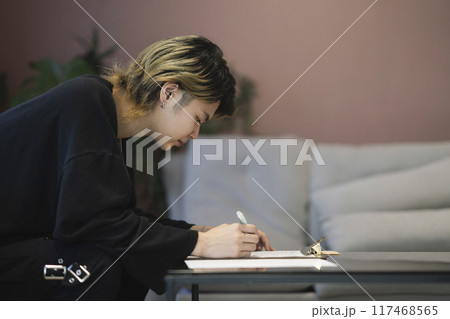 書類に記入する若い男性　横顔 117468565