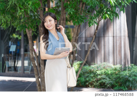 オフィス街でタブレット端末を持つビジネスウーマン オフィス街でタブレット端末を持つビジネスウーマン 117468588