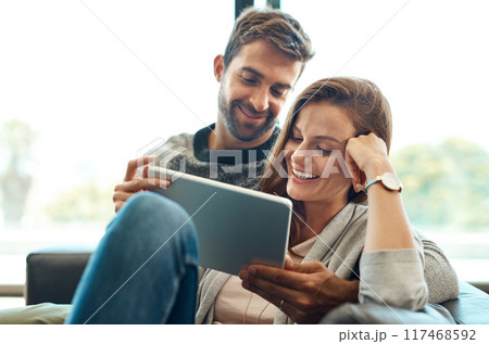 Excited, couple and tablet on sofa for streaming , movie selection or tv choice with communication at home. Smile, man and woman with technology and show options on couch for bonding and discussion 117468592