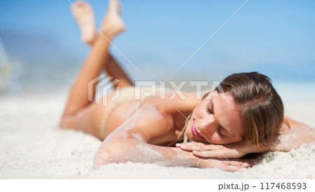 Relax, lying and woman on beach for tanning, sunbathing and outdoor on seaside with calm. Ocean, sand and female person in California for vacation, weekend holiday and adventure for summer break 117468593