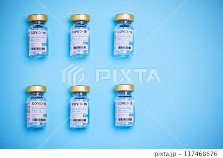 Medical, Covid vaccine and bottle in studio, innovation in health care for pandemic. Blue background, glass container and medicine with research for virus, chemistry development for human wellness 117468676