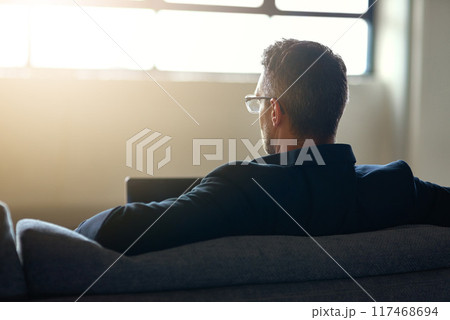 Businessman, glasses and remote work with laptop on sofa, professional website development for company. Male manager, computer with lens flare for digital job and creative designer from behind Businessman, glasses and remote work with laptop on sofa, professional website development for company. Male manager, computer with lens flare for digital job and creative designer from behind 117468694