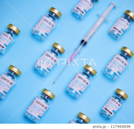 Medical, syringe and glass bottle of vaccine by blue background, treatment or illness prevention. Healthcare, medicine and injection for disease, coronavirus or covid 19 for immune wellness in studio Medical, syringe and glass bottle of vaccine by blue background, treatment or illness prevention. Healthcare, medicine and injection for disease, coronavirus or covid 19 for immune wellness in studio 117468696