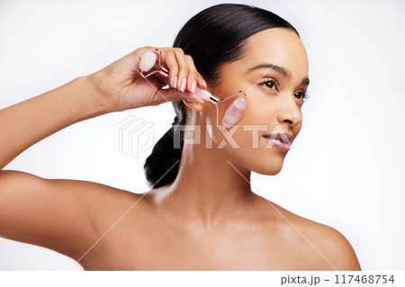 Anti aging, woman and rose quartz as face roller for beauty, detox and dermatology on white background. Female person, cosmetic tool and skincare for results in studio backdrop for wellness or glow 117468754