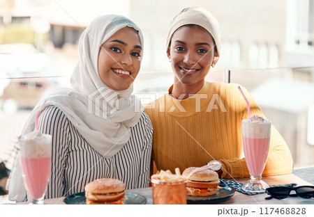 Islamic women, friends and portrait in cafe with smile for fast food, milkshake and relax for bonding. Girl, muslim people and happy with hijab, hamburger and reunion with connection in restaurant 117468828