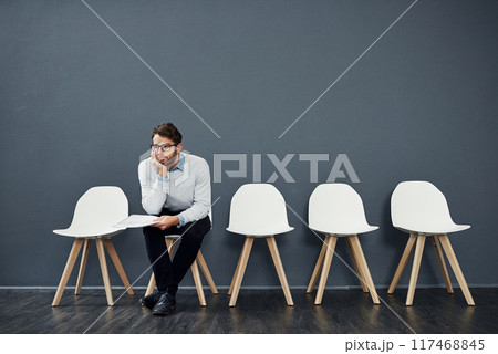 Waiting room, thinking and business man for recruitment, hiring or job interview in office. Chair, bored and male person as candidate of human resources, tired or impatient with paper by mockup space 117468845