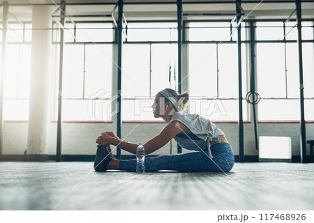 Fitness, music and stretching with woman on floor of gym for health, improvement or wellness. Exercise, legs and warm up for workout with athlete getting ready for physical improvement or training Fitness, music and stretching with woman on floor of gym for health, improvement or wellness. Exercise, legs and warm up for workout with athlete getting ready for physical improvement or training 117468926