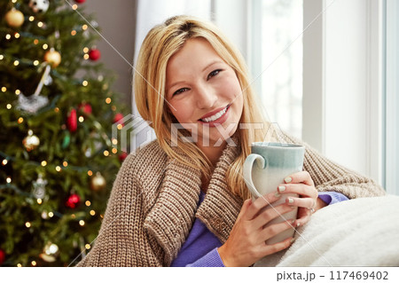 Christmas, happy woman and coffee on home couch with smile while thinking of memory. Portrait of lady with hot chocolate or tea cup to relax for festive holiday, season or winter vacation celebration Christmas, happy woman and coffee on home couch with smile while thinking of memory. Portrait of lady with hot chocolate or tea cup to relax for festive holiday, season or winter vacation celebration 117469402