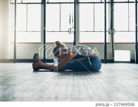 Fitness, legs and warm up with woman on floor of gym for health, muscle or wellness. Exercise, stretching and training for workout with athlete getting ready for physical improvement routine 117469586