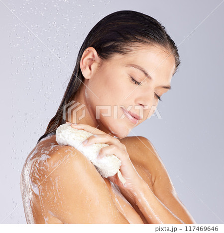 Woman, showering and soap in studio, morning and water for cleaning of body, hand and scrub for hygiene. Purple background, relax and routine of grooming, foam and washing of person with product 117469646