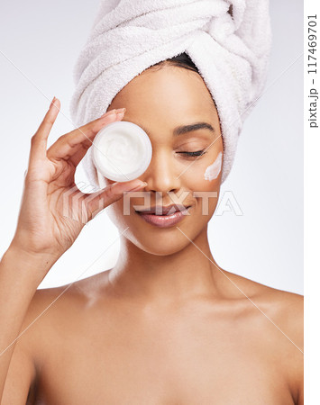 Skincare cream, hand and woman in studio with eyes closed for cosmetics, natural glow or treatment on white background. Towel, body and model with product for satisfaction, dermatology or moisturizer 117469701