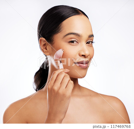 Portrait, woman and rose quartz in skincare for beauty, anti aging or dermatology on white background. Female person, cosmetic tool and face roller for results in studio backdrop for wellness or glow Portrait, woman and rose quartz in skincare for beauty, anti aging or dermatology on white background. Female person, cosmetic tool and face roller for results in studio backdrop for wellness or glow 117469768
