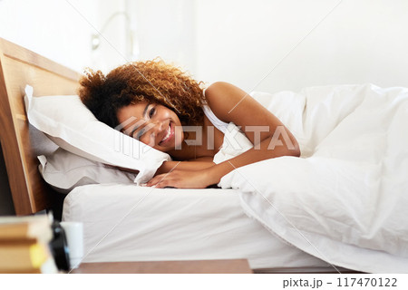 Relax, portrait and black woman with smile in bedroom, morning and wake up in home, wellness and apartment. House, happiness and African girl with joy, person and rest with peace, comfort and lazy 117470122