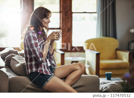 Coffee, happy and thinking with woman on sofa in living room of home for morning or weekend time off. Drink, relax or smile and person in apartment with fresh caffeine beverage for break or wellness Coffee, happy and thinking with woman on sofa in living room of home for morning or weekend time off. Drink, relax or smile and person in apartment with fresh caffeine beverage for break or wellness 117470532