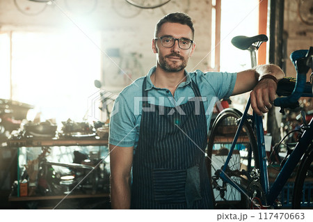 Portrait, serious and man with bike for technician career, small business and entrepreneur in maintenance garage. Mature guy, bicycle mechanic and professional skills for repair in service workshop 117470663