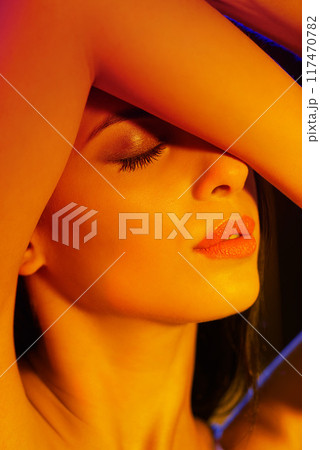 Studio, woman and cosmetic in artistic lighting with eyes closed, cover and hand for mascara or eyeshadow. Model, beauty and creative aesthetic for art deco, light and makeup for skincare or facial 117470782