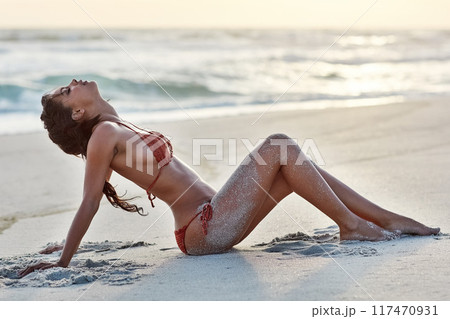 Beach, relax and woman in bikini, sand and rest on ground, nature and trip for vacation in California. Holiday, girl and person in summer with swimsuit, peace and wellness in ocean, calm and sunset Beach, relax and woman in bikini, sand and rest on ground, nature and trip for vacation in California. Holiday, girl and person in summer with swimsuit, peace and wellness in ocean, calm and sunset 117470931